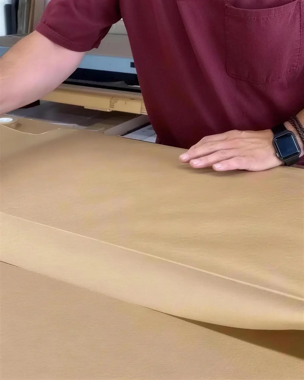 A finished piece being wrapped in kraft paper for shipping