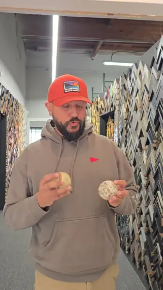 Medi holding two baseballs in the moulding aisle at the showroom
