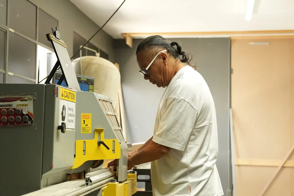 A framer feeding a length of moulding into the saw