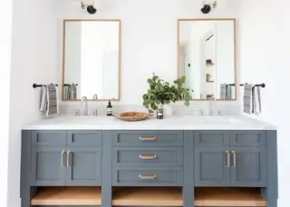 Two oak-framed mirrors above a slate-blue double vanity