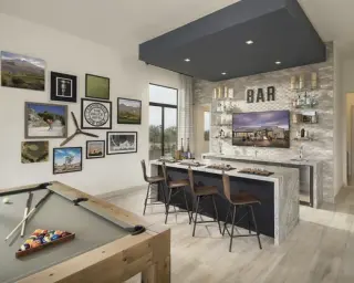 A bar lounge with a collected gallery wall of framed landscape photographs, an emblem and a propeller, a pool table in the foreground