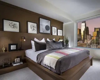 Five black-framed line-drawing prints stepped across a walnut headboard wall in a bedroom with a city view