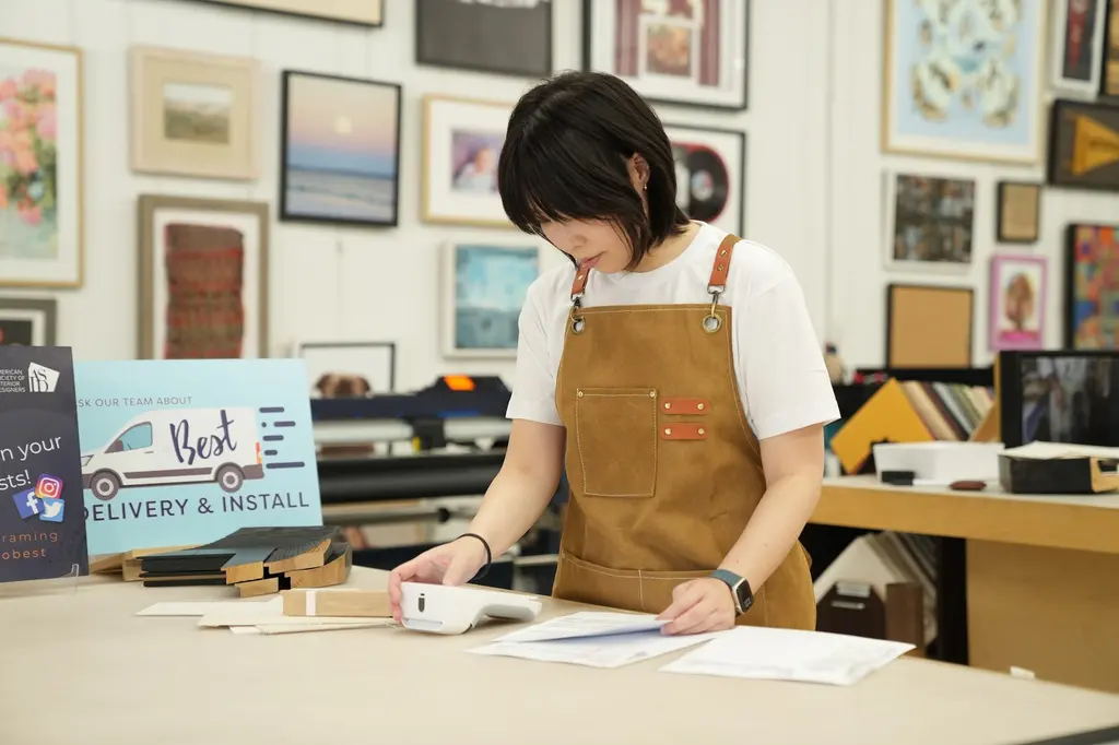 A designer at the counter beside the Best Delivery and Install sign