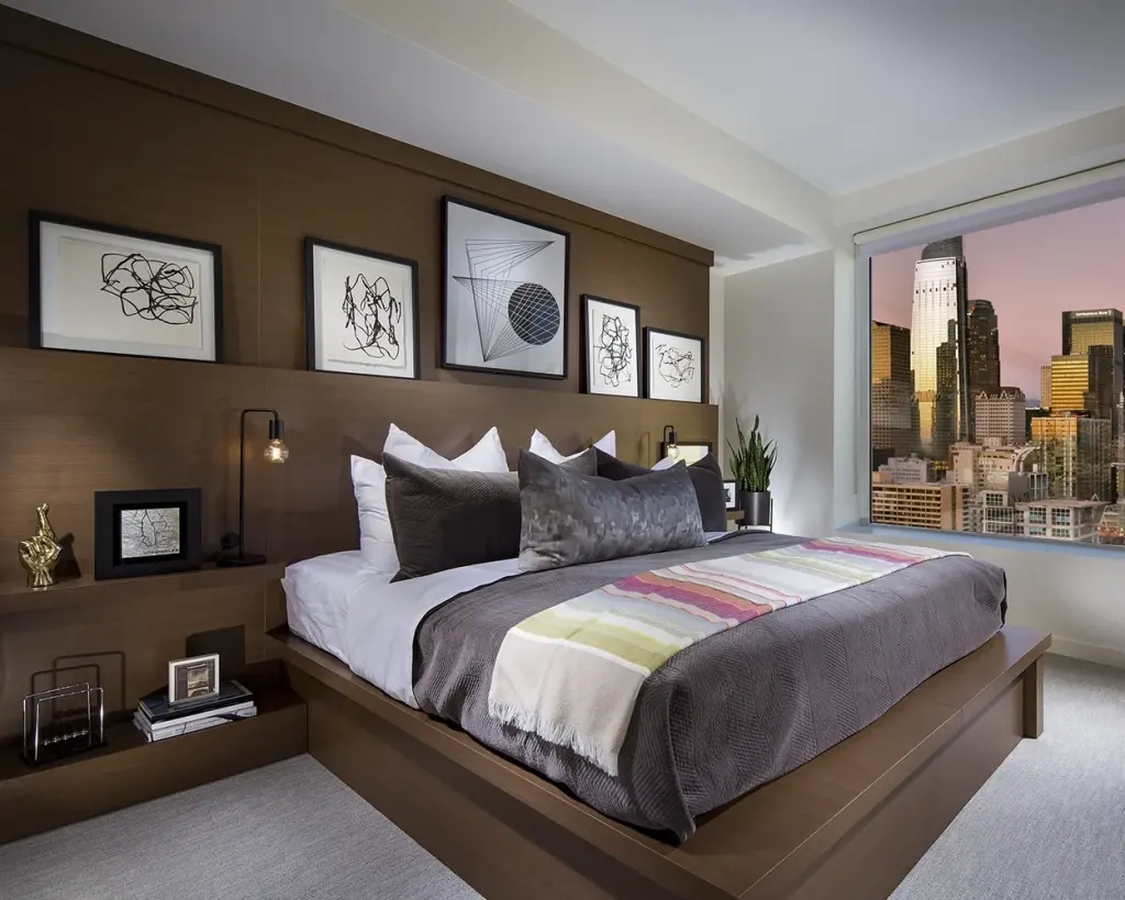 A five-piece series of framed black-and-white prints over the headboard wall of a city-view bedroom suite