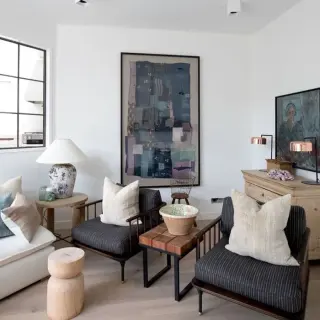 Oversized framed indigo textile collage above seating in a bright living room