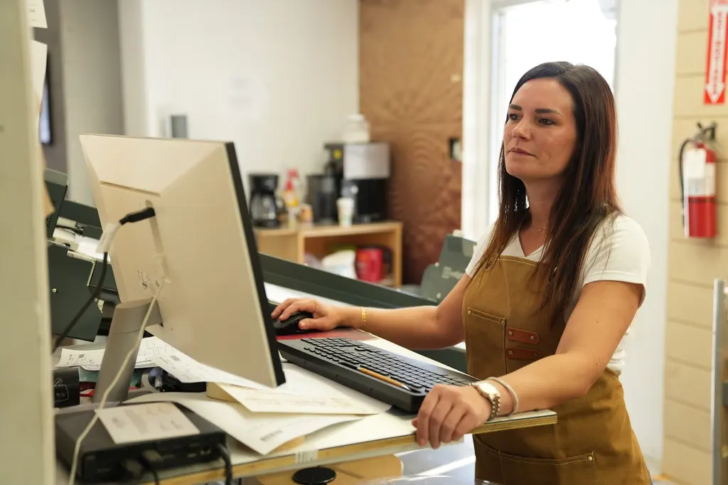 A designer at the front desk computer, writing up an order