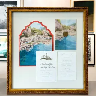 Gilt shadow box holding a Sicilian wedding invitation suite, watercolor and wax seal