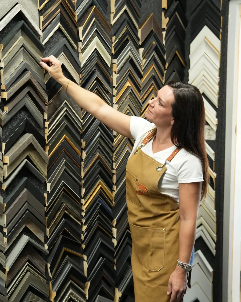 Kristen reaching up to a corner sample on the moulding wall