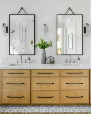 pair of black framed mirrors over a white oak double vanity