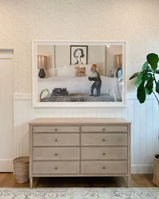 Wide white-framed monkey photograph over a limed oak dresser