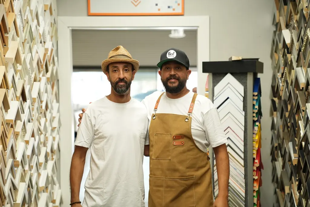 Medi and Karim in the doorway between the moulding walls