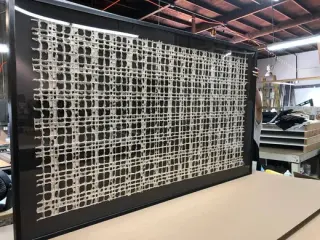 Bone-white woven lattice textile floated on black, tilted on the work table