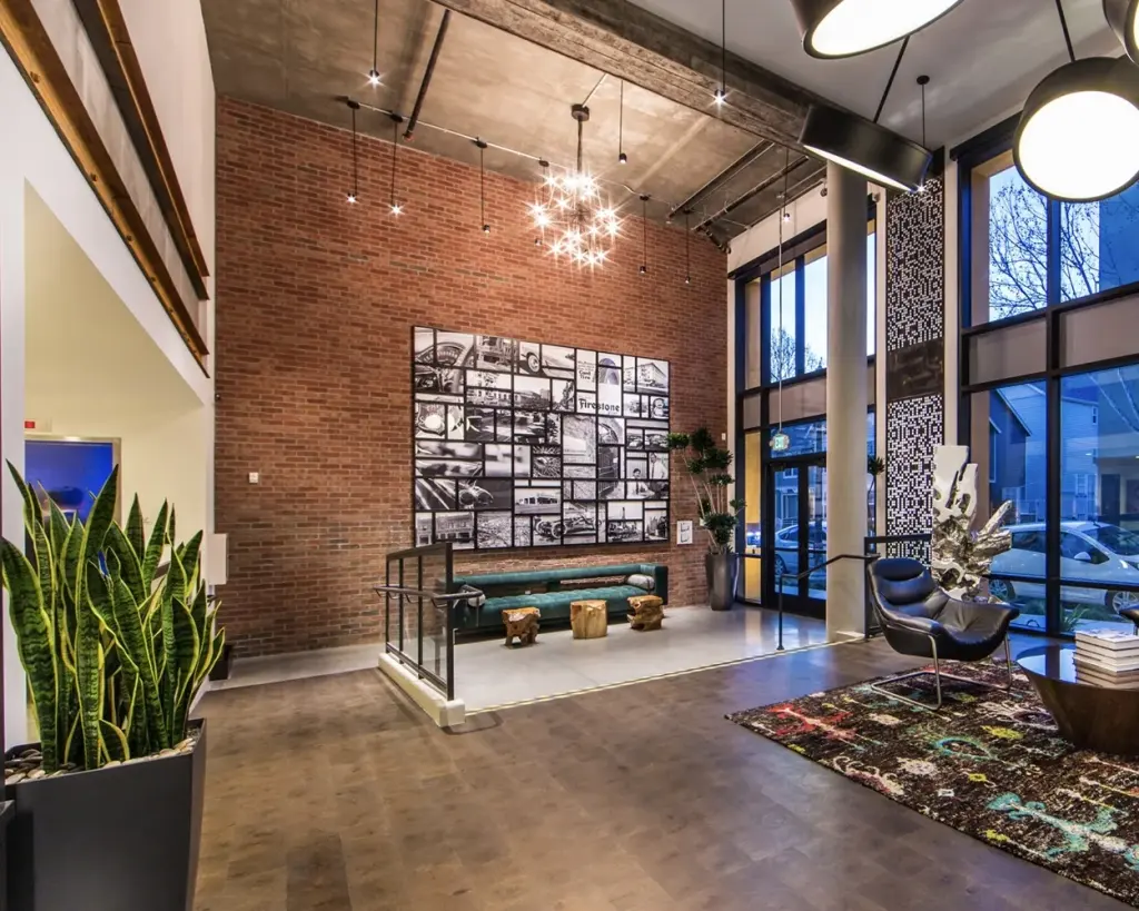 A lobby with a brick wall hung with a large grid of framed photographs