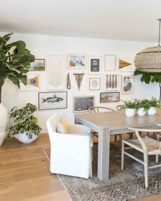 Coastal dining room with a full salon-hung gallery wall of prints, pennants and framed objects