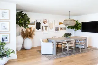 Coastal dining room with a full eclectic gallery wall: swimsuits, pennants, oars, seascapes in pale frames