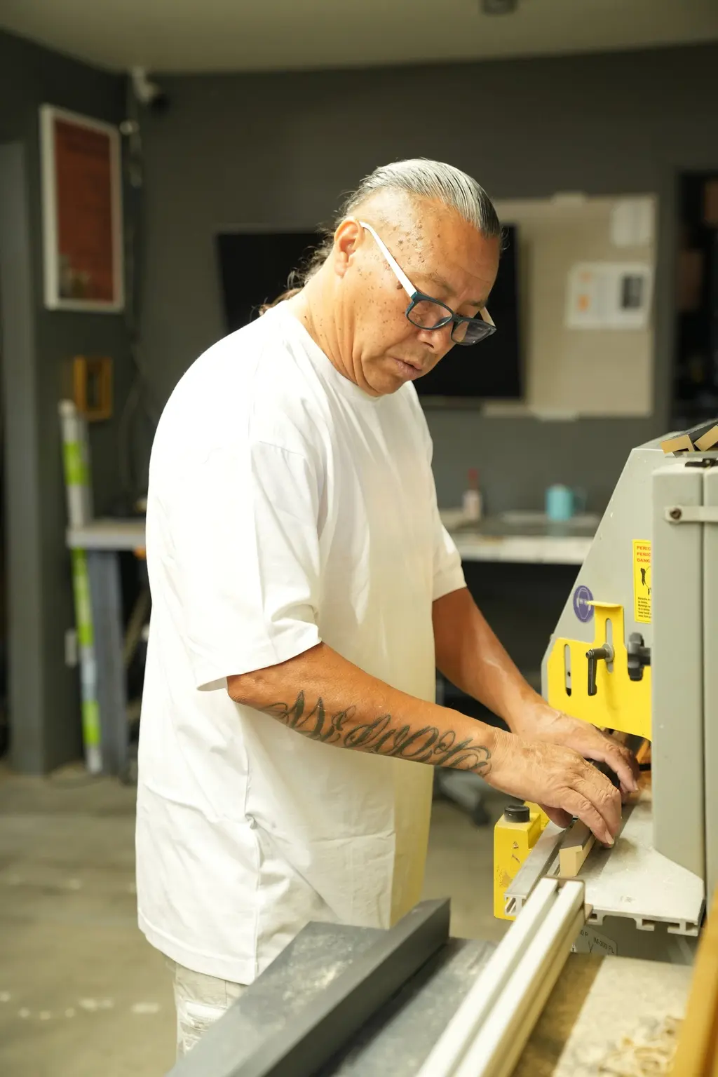 A framer setting a length of moulding against the fence of the chop saw