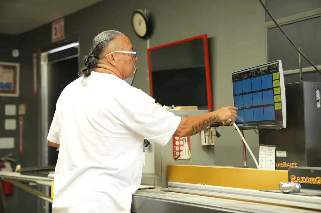 A framer setting a cut on the computerised saw touch screen