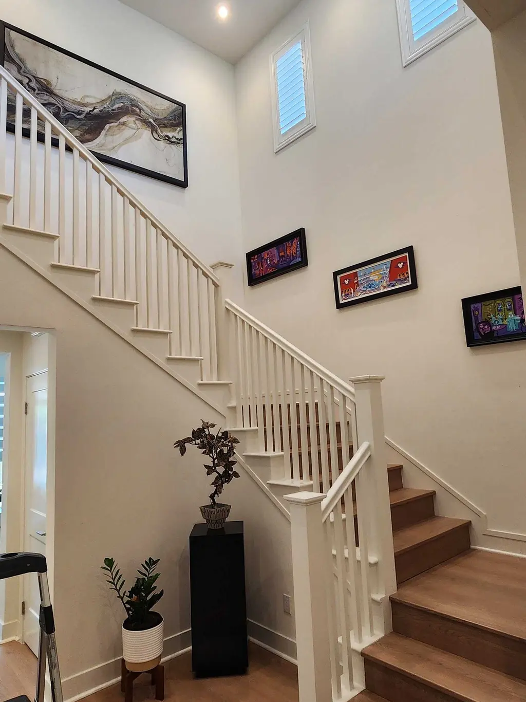 Framed artwork hung up a white staircase