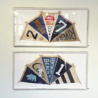Two framed sets of vintage triangular surf pennants, Bolsa, River, Cliffs and Huntington Beach among them, mounted on white in matching pale frames