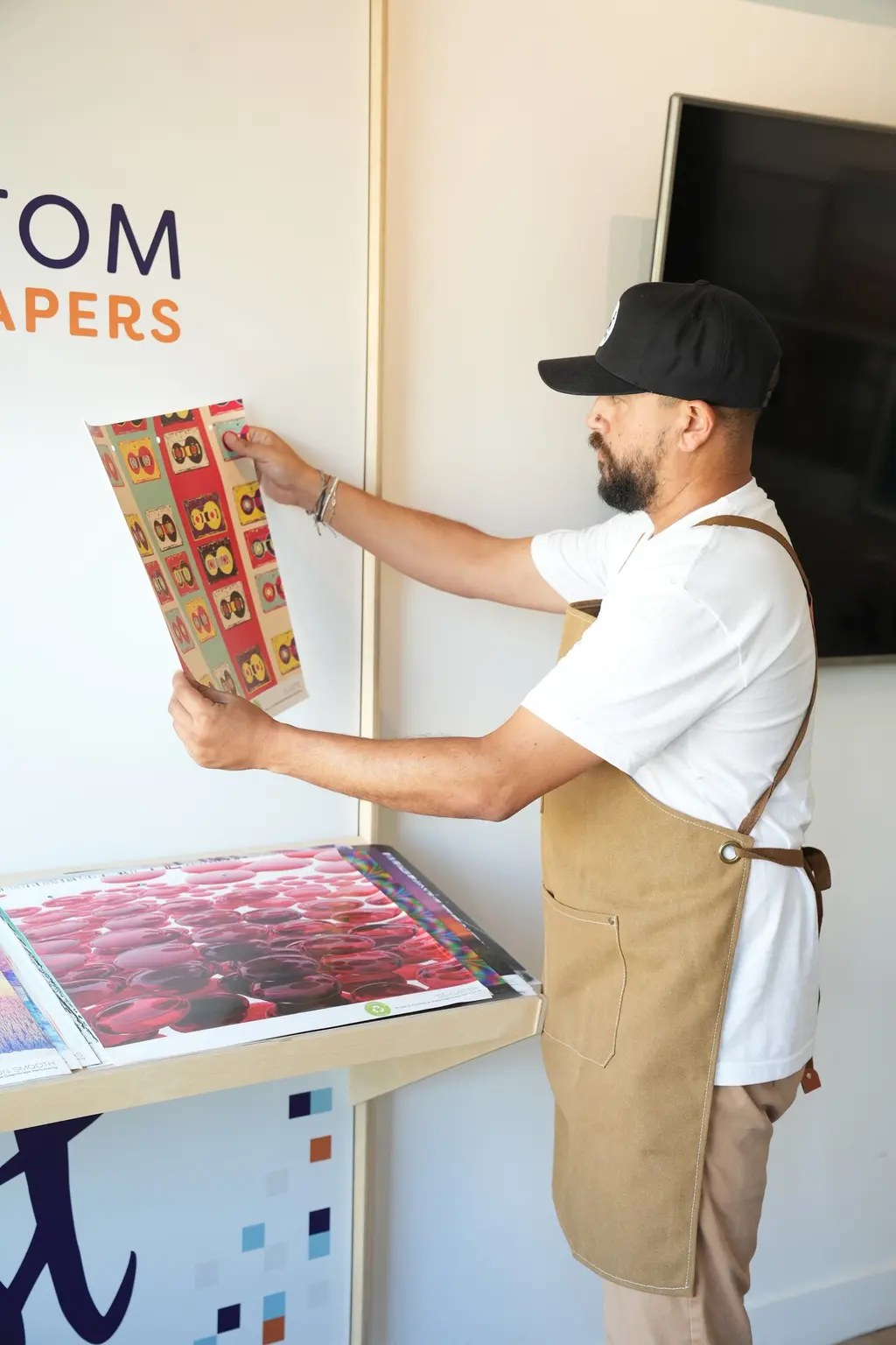 Medi holding up a printed wallpaper sample in the print area